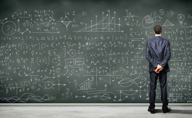 Man standing in front of board of equations